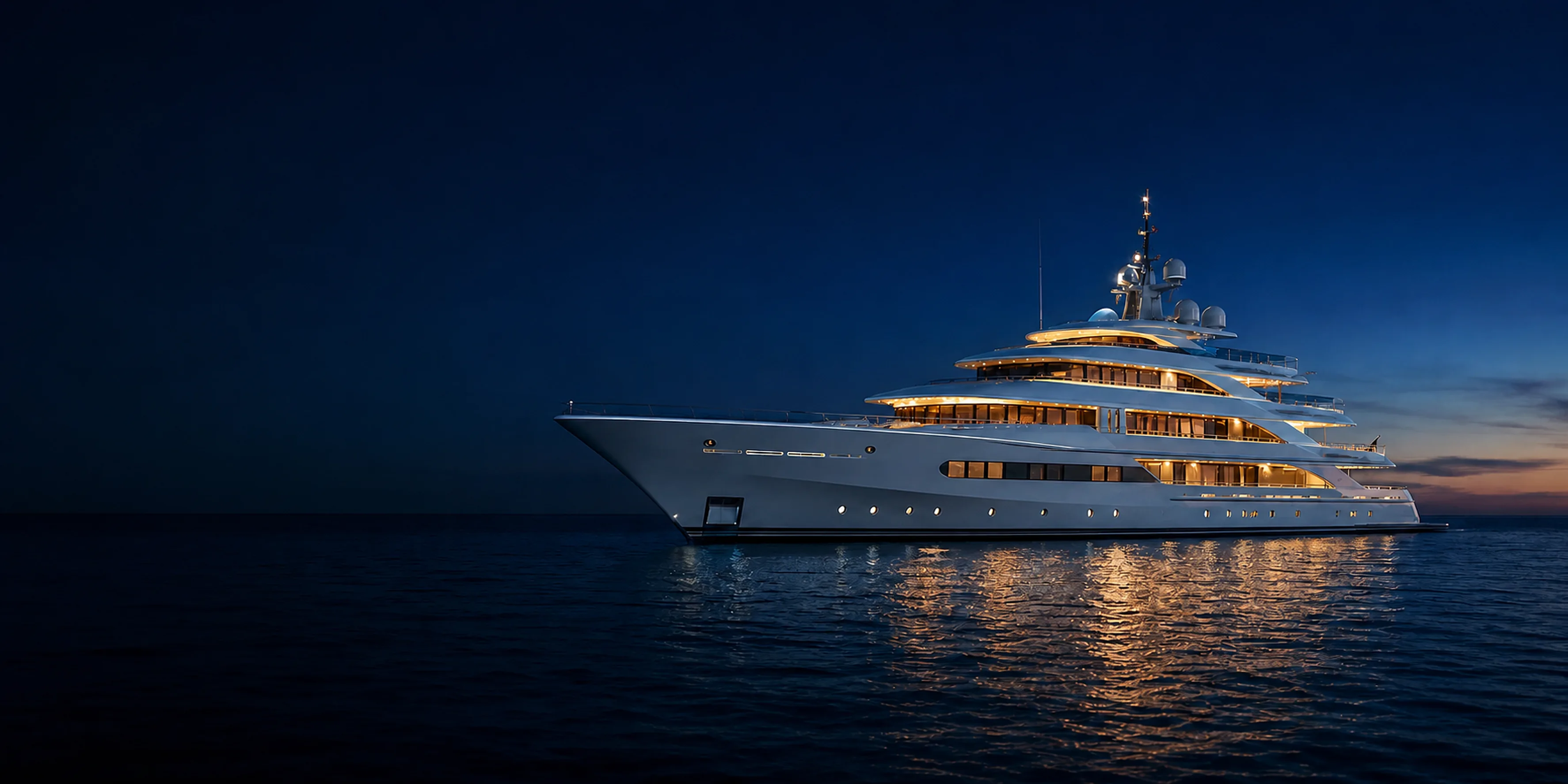 Illuminated modern superyacht at blue hour on open water